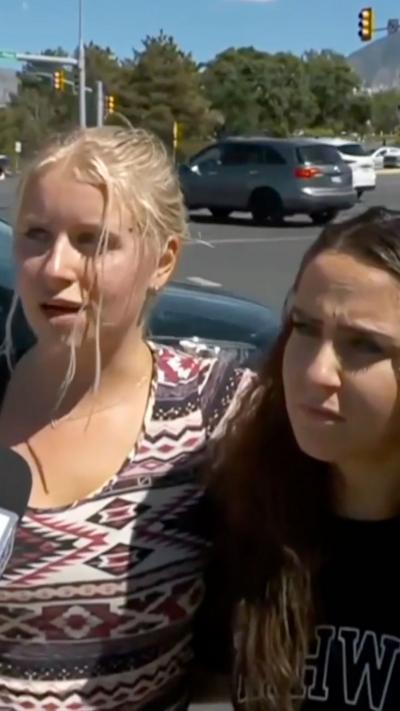 Two girls standing in parking lot being interviewed