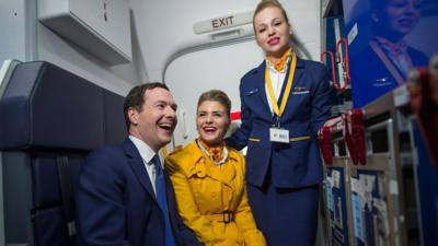 George Osborne tries his hand at being a member of cabin crew to push the Remain message.