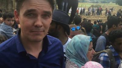 James Reynolds with migrants at the border into Macedonia