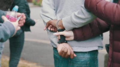 A black man is handcuffed