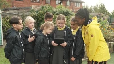 Shanequa and school children examining nature