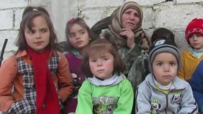 Woman sitting with seven children