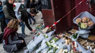 People leave floral tributes at the main entrance of Le Carillon restaurant on November 14, 2015 in Paris