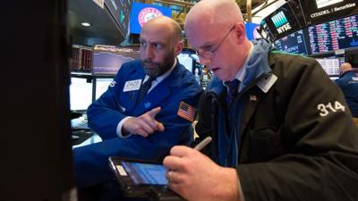 Traders talking on the New York Stock Exchange trading floor