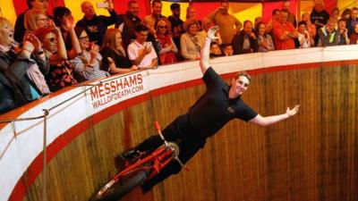 A performer riding the wall of death