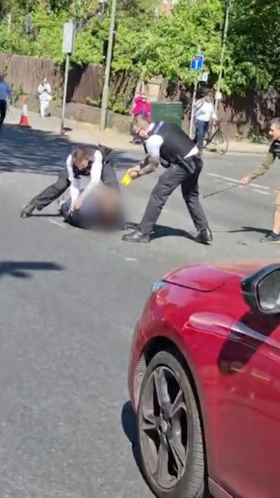 Two police officers standing above man laying on the floor
