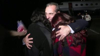 Man hugging two women