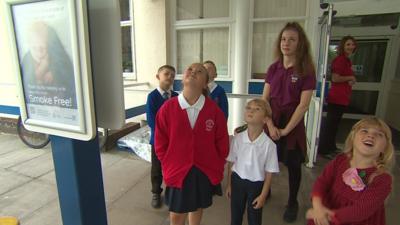 Children looking up at speakers