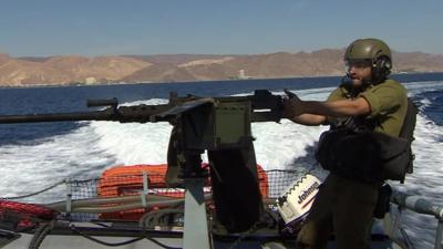 Israeli soldier on a boat with a gun