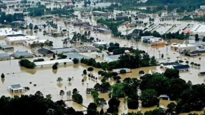 Aerial footage of historic floods across Louisiana. Many buildings are under water.