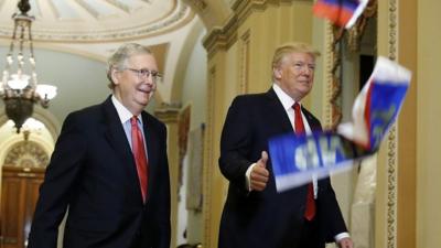 Russian flags thrown from a protester fall in front of President Trump