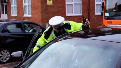 Police officer talking to driver of car