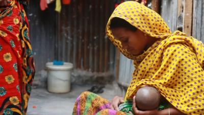 A mother breast feeds her baby