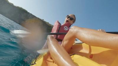 Amanda Holden falls out of a yellow kayak. She is wearing a red life jacket