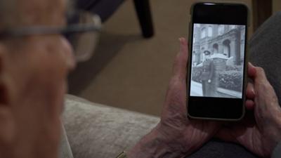 92-year-old George Vulkan looking at his younger self in the British army