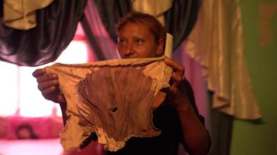 Romani woman showing a bloodied piece of cloth