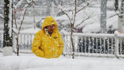 A man walks during snowfall in Yantai in China's eastern Shandong province on 12 December 2017