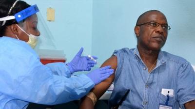 A file photo taken on 3 February 2015 shows Doctor Francis Kateh (right) from Redemption Hospital volunteering to receive a trial vaccine against in Monrovia