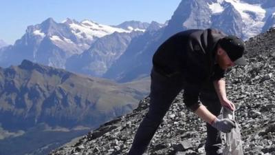 Volunteer collects rubbish in the Swiss Alps