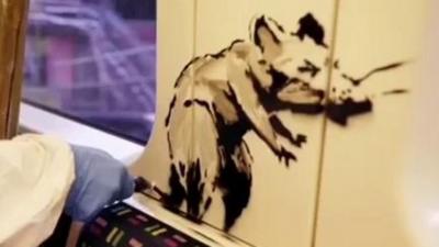 Banksy's latest artwork encourages London Underground passengers to wear face masks.