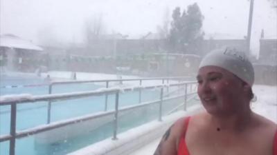 Female swimmer standing next to outdoor pool