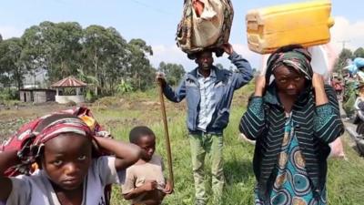 People with their belongings travelling on foot