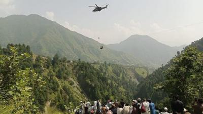 People watch the helicopter rescue operation.