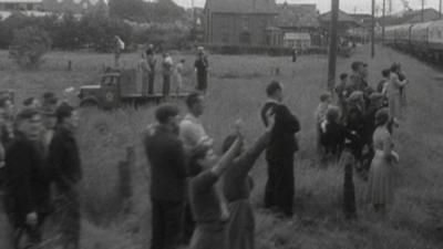 Onlookers wave to the Queen