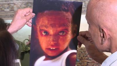 Nisha's parents holding her baby photo