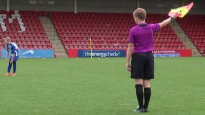 Young referee in a purple shirt