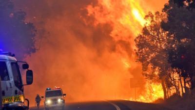 A handout photo taken on January 7, 2016 and released on January 8 by the Department of Fire and Emergency Services shows firefighters battling a fire near Yarloop in Western Australia. The out-of-control blaze 110 kilometres (68 miles) south of Perth more than doubled in size in 24 hours and has now burned through 53,000 hectares (130,000 acres), with a third of the town of Yarloop destroyed.