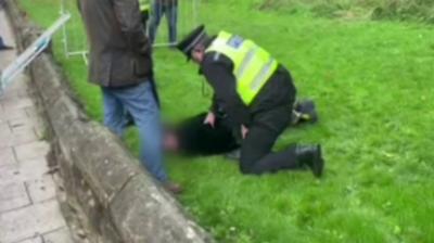 A man being detained by police