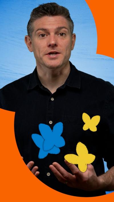 A man with short dark hair wearing a black shirt talks to the camera. A graphic of two blue and two yellow butterflies fly in front of him.