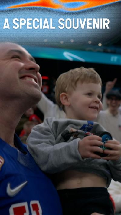 Young American ice hockey fan smiles after catching an ice hockey puck