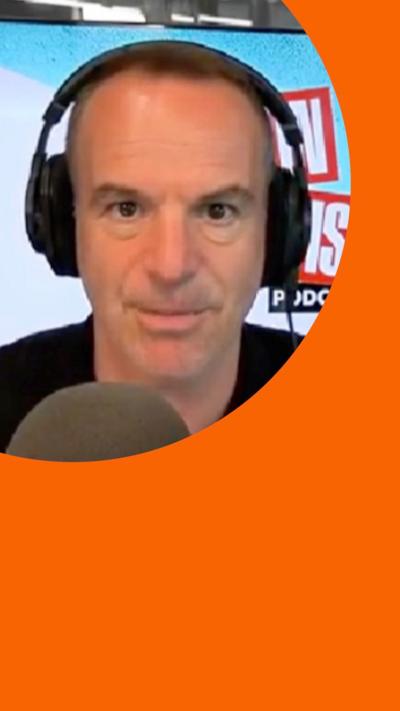 Martin Lewis speaks into a mic while wearing headphones