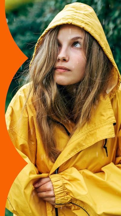 A young woman wearing a yellow raincoat in a rainy weather