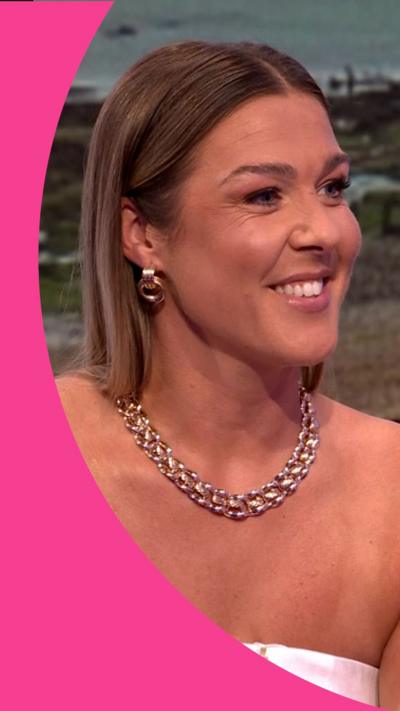 Mary Earps in a white top and silver necklace sitting on a green sofa in the One Show Studio.