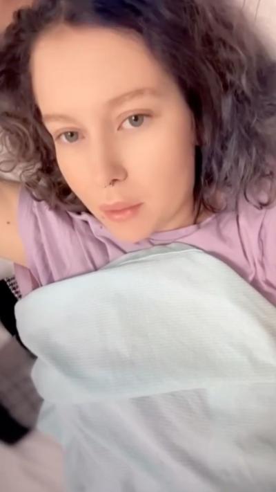 A young woman wearing a pink top