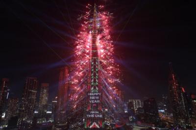 Burj Khalifeh with fireworks coming from it, projection on it reads "Happy New Year form the UAE"