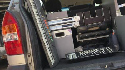 Used electronics seen stacked in a car boot