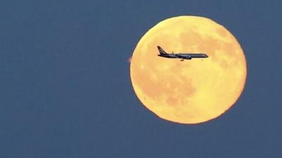 Blue moon with plane in front of it