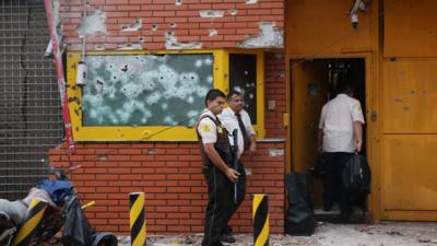 Employees remain outside the premises of multinational company Prosegur after a robbery in Ciudad del Este, Alto Parana department, Paraguay, in the triple border with Brazil and Argentina on April 24, 2017