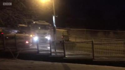 A runaway lorry crashes on a snowy street.