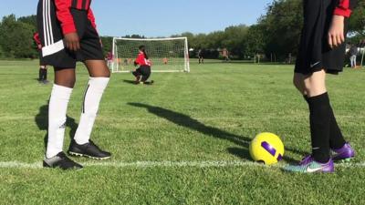 Two girls playing football