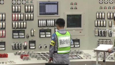 Worker standing in front of control panel at Sendai plant