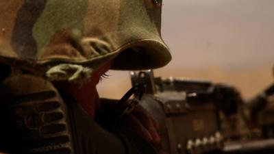 An Afghan soldier fires a machine gun