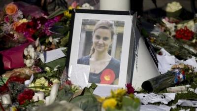 A photograph of Jo Cox stands amongst tributes laid in her memory in Parliament Square, London