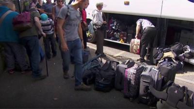 People with luggage outside bus