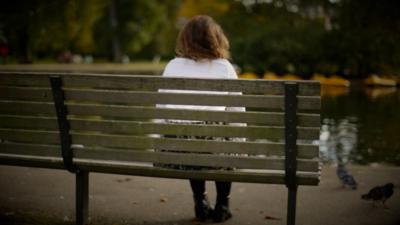 woman sitting on a bench looking into the distance