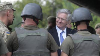 Michael Fallon, speaks with Ukrainian soldiers on the military base outside Zhitomir, Ukraine, Tuesday, Aug. 11, 2015